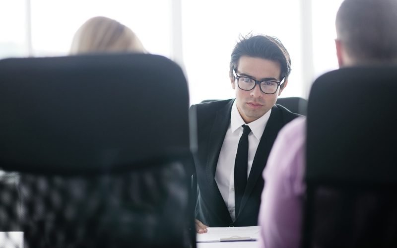 Confident young business man attending a meeting with his colleagues