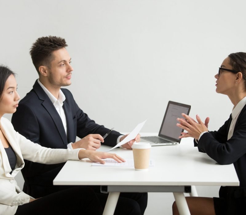 Female job applicant interviewed by two HR managers reading her resume, employee talking about experience, sharing thoughts during recruitment process. Concept of hiring, employment, cooperation